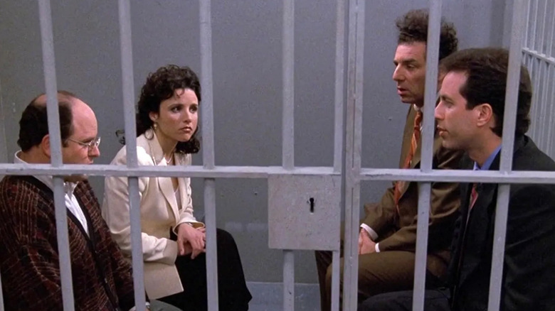 George, Elaine, Kramer, and Jerry sitting in a jail cell on 
